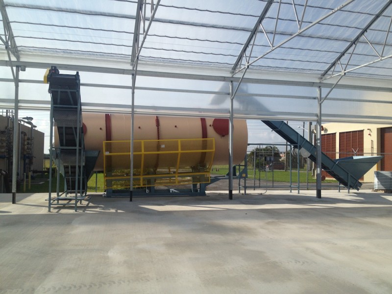 B&K 24 ft. long by 8 ft. diameter in-vessel composter with the loading conveyor on the right and the downloading conveyor on the left.